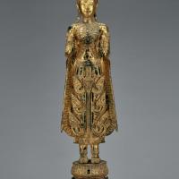 Standing bronze Buddha sculpture draped in royal clothing